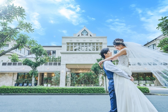 アルコラッジョ・マリエールの前で撮影している新郎新婦