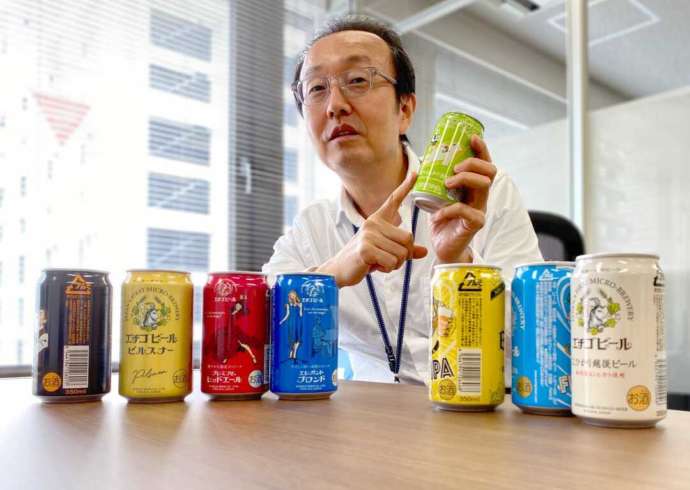エチゴビールの商品と一緒に写る別所さん