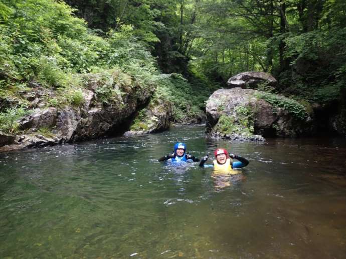 晴れた日の尾瀬の渓流で遊ぶ2人組の様子