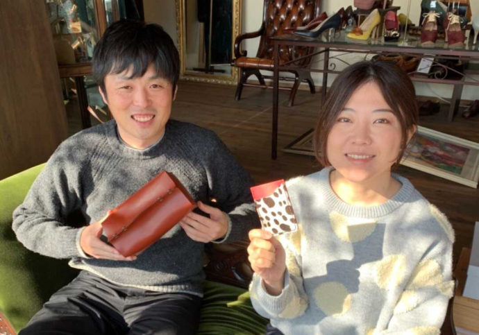 小物入れを見せて笑う男性とカード入れを見せて笑う女性