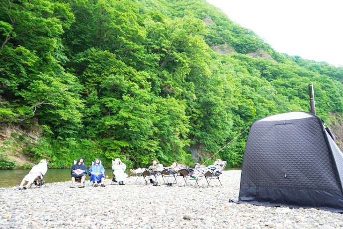 北海道札幌市にある「野あそびベース フリルフスリフ」でSUPとテントサウナを体験している人たち
