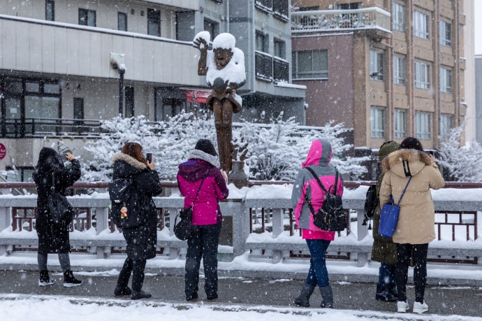 高山市の観光地で写真撮影を楽しむハッピープラスのツアー参加者