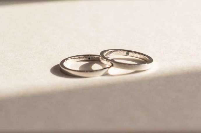 指輪の裏側に刻印と宝石を施したハッピーリボンのペア結婚指輪