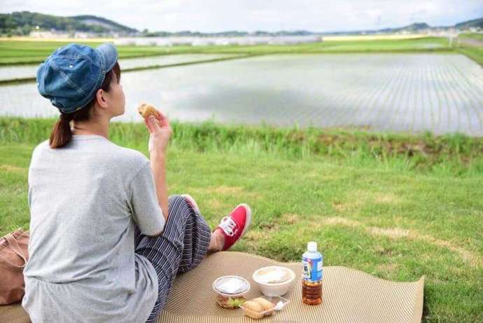 道の駅ましこの芝生に座ってご飯を食べている女性