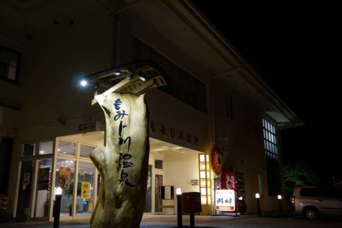 もみじ川温泉のロゴが彫り込まれた杉のオブジェ
