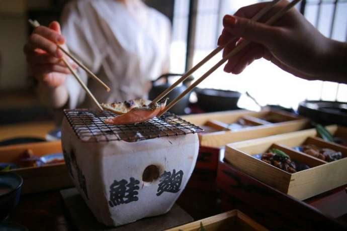 七輪で塩引き鮭を焼く様子
