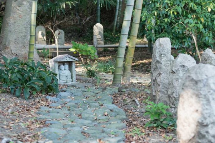 石仏が並ぶ中に通る散策路の写真
