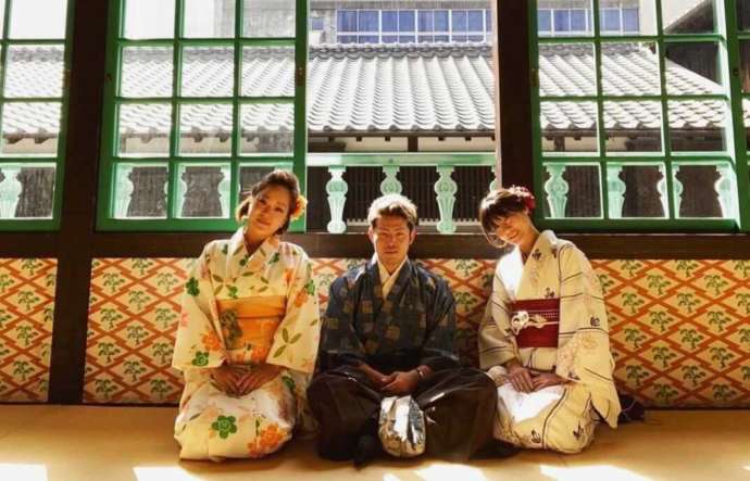 出島はいからさんの着物を着てカピタン部屋の唐壁の前に並ぶ利用者の写真
