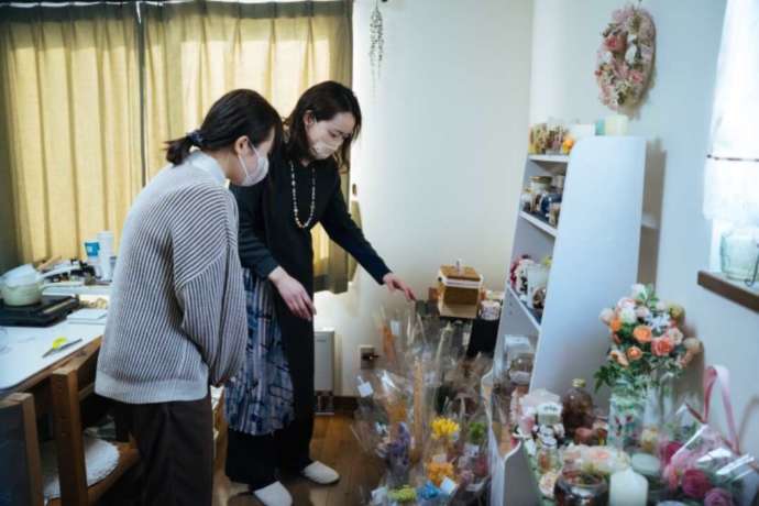 ナチュラルアロマライフで花の説明をする講師と女性