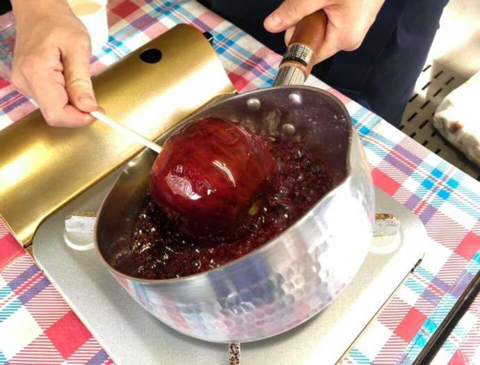 りんごに飴をまとわせている様子
