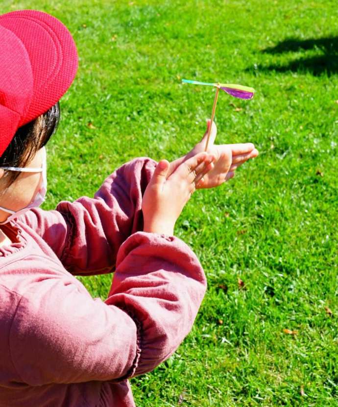 木工体験で制作した竹とんぼを飛ばそうとしている子供