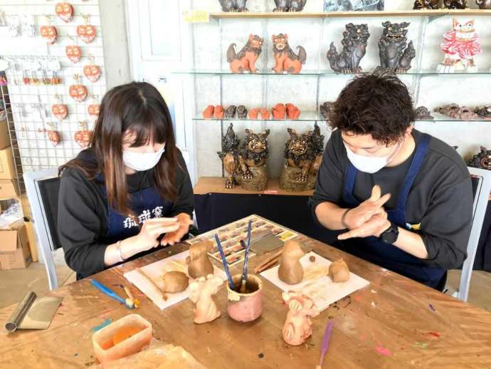 陶器シーサー作り体験制作中のカップル写真