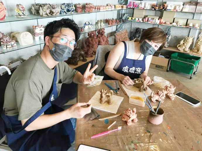 陶器シーサー浮作り体験制作中のカップルの写真