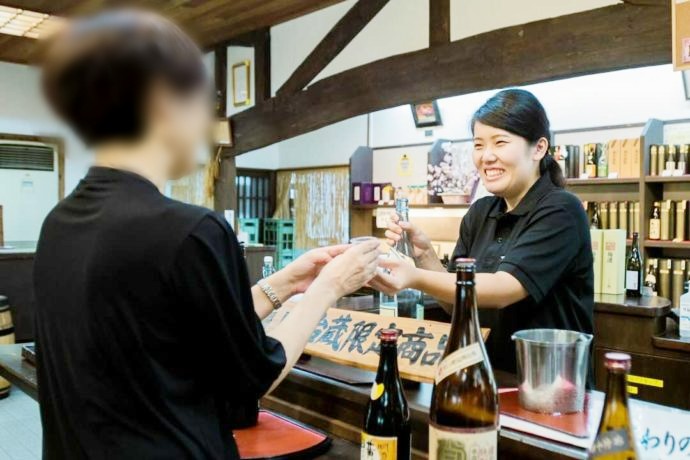 薩󠄀摩酒造「花渡川蒸溜所 明治蔵」で焼酎の試飲をする様子