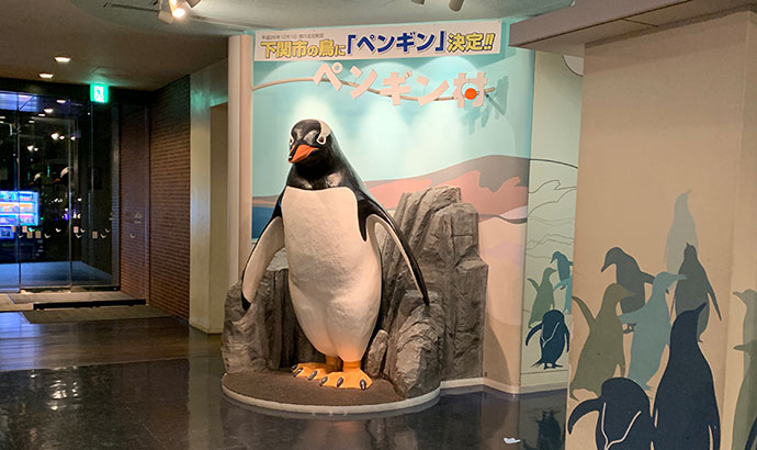 入り口横のジェンツーペンギン像。床の足跡を進むとツアーカウンターへ。