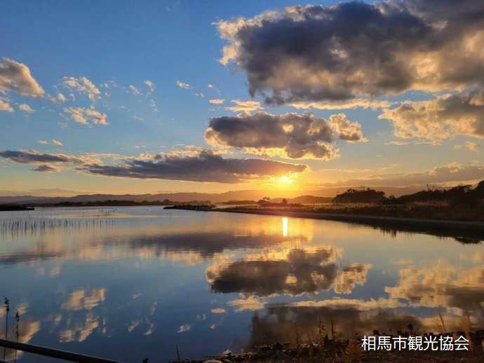 夕陽の広場で夕方の海に空が映る様子