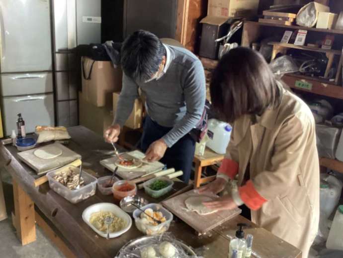 杉乃精でピザのトッピングをするカップル