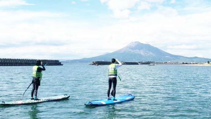 鹿児島県垂水市の「道の駅たるみずはまびら たるたるぱあく」の近くでSUPをしているカップル