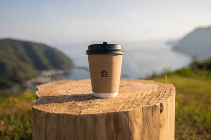 管理棟でテイクアウトしたコーヒーと高平キャンプ場からの眺め