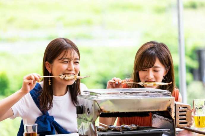 鮎ガーデンで女の子が焼き立ての鮎を頬張っている様子