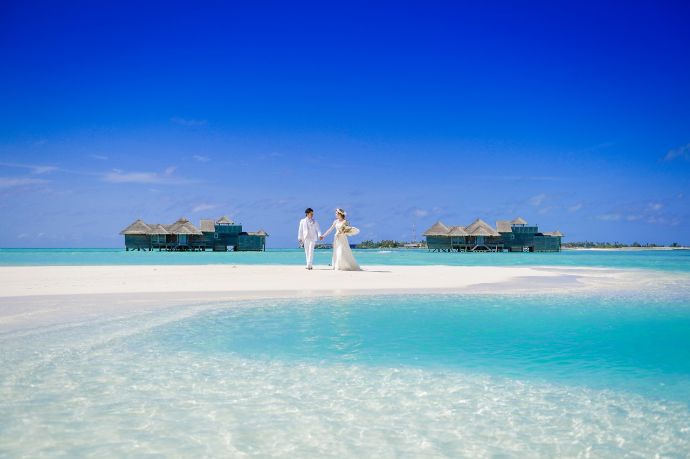 「ムーンシェル」のウエディング:青い空と海をバックに撮影をする新郎新婦