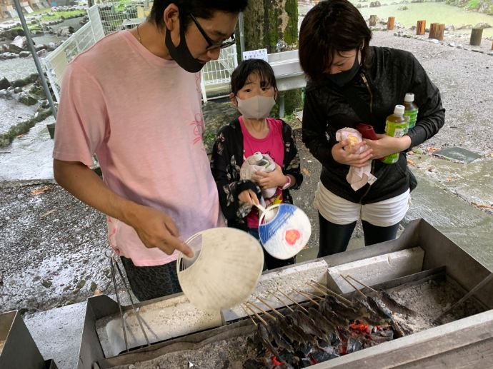 やまめ平でヤマメの塩焼き体験を楽しむ利用者