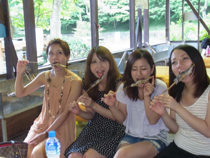 やまめ平でヤマメの塩焼きを食べる女性客